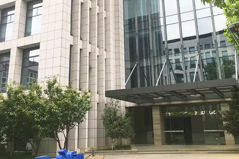 Oficina TopXGun edificio alto de cristal con un cartel delante de la entrada